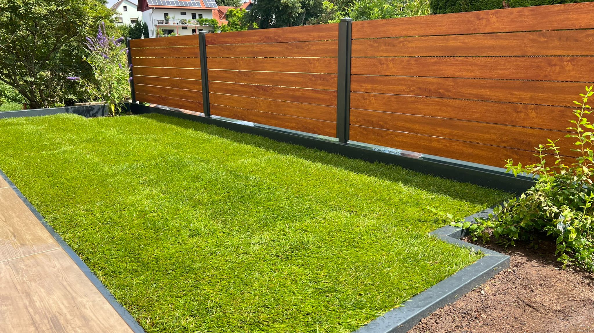 Rasenfläche mit Beeteinfassung und Sichtschutzzaun