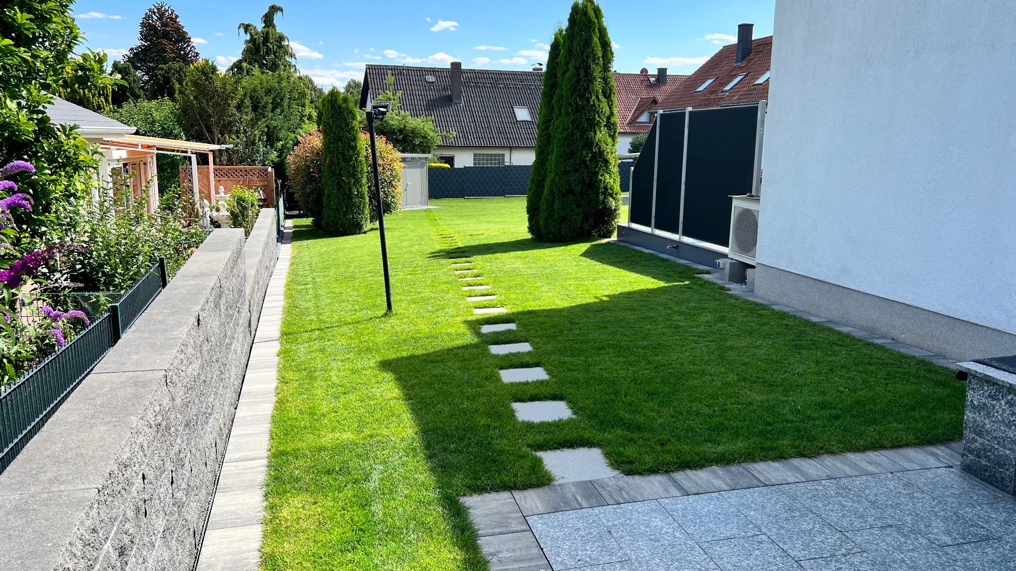 Gartenanlage mit Rasen und Sichtschutzzaun